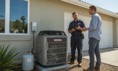 HVAC technician explaining how an air conditioner works to a homeowner outside a house in Southern California, highlighting that aircon uses electricity and refrigerant—not fuel gas. Answering the question: does aircon use gas?